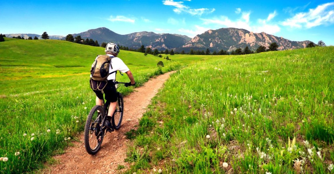 Mountain biker rides the Flatirons VIsta Trail near Boulder, Colorado Mountain biker rides the Flatirons VIsta Trail near Boulder, Colorado