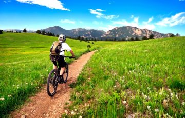 Mountain biker rides the Flatirons VIsta Trail near Boulder, Colorado Mountain biker rides the Flatirons VIsta Trail near Boulder, Colorado